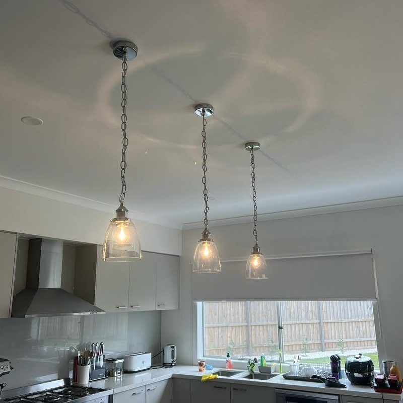 Kitchen with three glass pendant lights and ceiling downlights